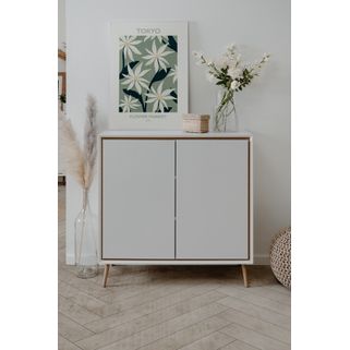Komoda 2-drzwiowa ARONA - biały Minimalistyczna komoda Arona w kolorze białym z detalami w odcieniu dąb artisan to elegancka propozycja dla miłośników...