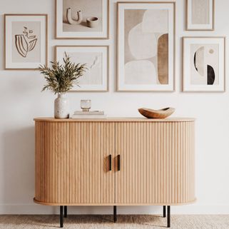 Komoda owalna z drzwiami przesuwnymi KASJA 120 cm - dąb Komoda Kasja 120 cm to elegancki mebel doskonały do nowoczesnych wnętrz. Łączy w sobie dekor o...